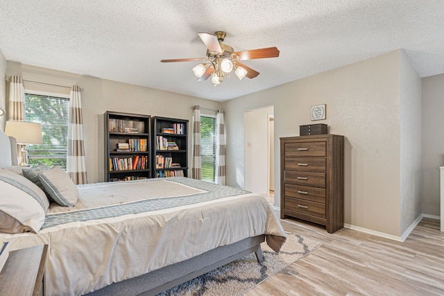 140 Amory Dr, Benbrook, TX 76126 - bedroom featuring light wood-type flooring, baseboards, a textured ceiling, and a ceiling fan