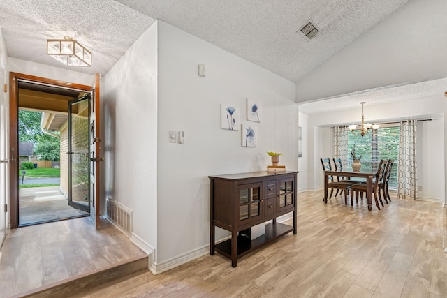 140 Amory Dr, Benbrook, TX 76126 - foyer entrance with a textured ceiling, a chandelier, light wood-style floors, plenty of natural light, and vaulted ceiling