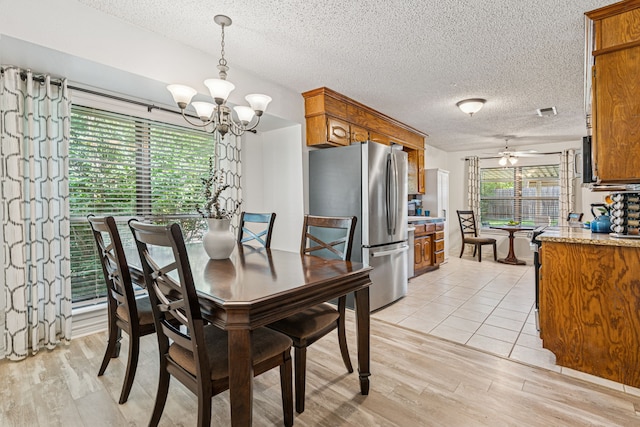 140 Amory Dr, Benbrook, TX 76126 - dining area featuring a chandelier, light wood-style floors, ceiling fan, and a textured ceiling