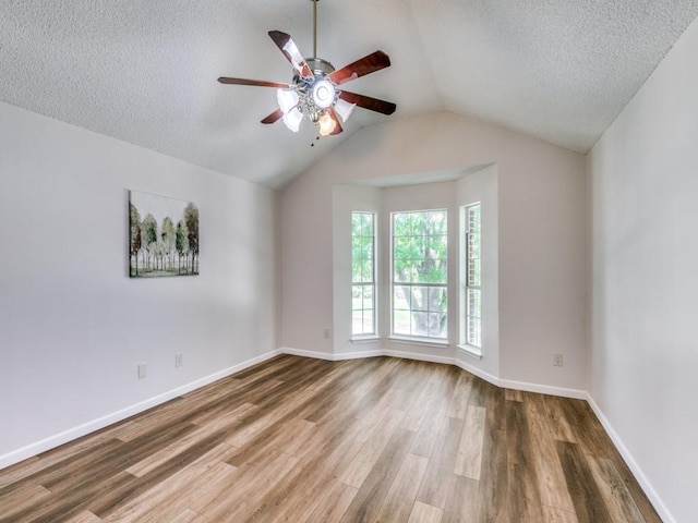 750 Pulitzer Ln, Allen, TX 75002 - spare room with a ceiling fan, wood finished floors, a textured ceiling, vaulted ceiling, and baseboards