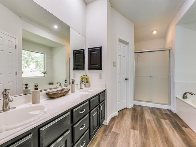 750 Pulitzer Ln, Allen, TX 75002 - bathroom featuring a bath, double vanity, a stall shower, wood finished floors, and recessed lighting