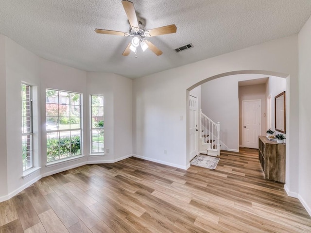 750 Pulitzer Ln, Allen, TX 75002 - unfurnished room featuring arched walkways, light wood-style floors, a textured ceiling, baseboards, and ceiling fan