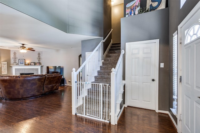 8405 White Stallion Trl, Mckinney, TX 75070 - entrance foyer featuring wood finished floors, stairway, ceiling fan, a fireplace, and a towering ceiling