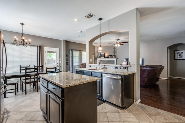 8405 White Stallion Trl, Mckinney, TX 75070 - kitchen featuring stainless steel dishwasher, open floor plan, arched walkways, a ceiling fan, and a kitchen island