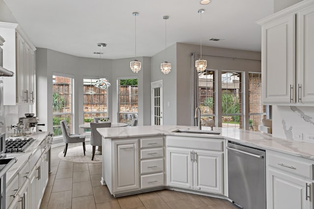 1912 White Oak Rd, Mckinney, TX 75072 - kitchen with stainless steel appliances, a sink, a peninsula, a chandelier, and white cabinets