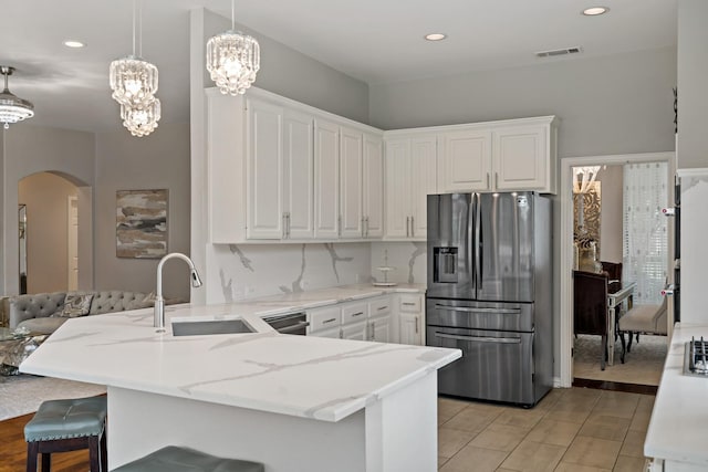 1912 White Oak Rd, Mckinney, TX 75072 - kitchen with stainless steel refrigerator with ice dispenser, a peninsula, arched walkways, a sink, and white cabinets