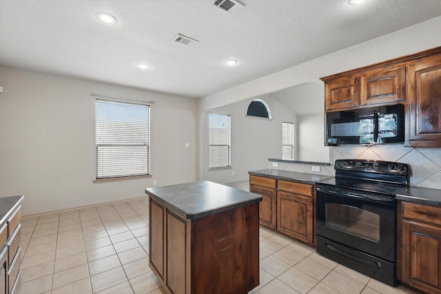 3512 Hornbeam St, Denton, TX 76226 - kitchen featuring black appliances, dark countertops, a center island, light tile patterned floors, and recessed lighting