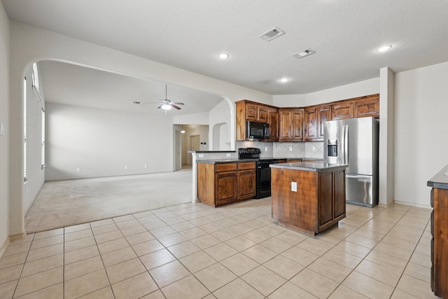 3512 Hornbeam St, Denton, TX 76226 - kitchen featuring arched walkways, black appliances, light colored carpet, dark countertops, and recessed lighting