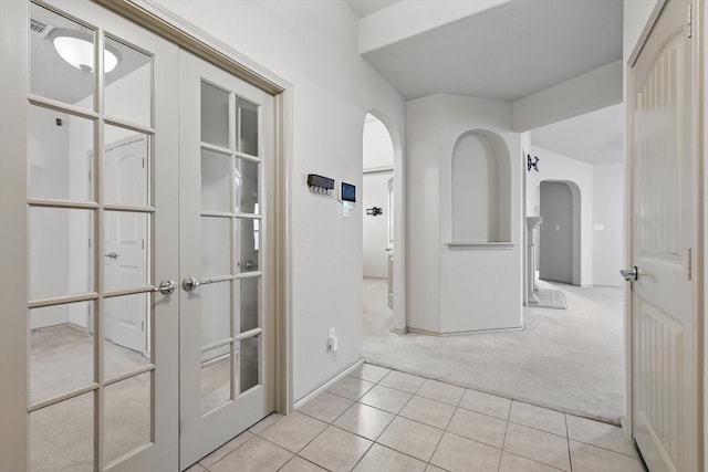 3512 Hornbeam St, Denton, TX 76226 - hall with arched walkways, light colored carpet, light tile patterned flooring, and french doors