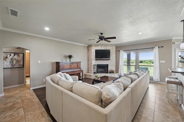 1225 County Road 1021, Burleson, TX 76028 - living room featuring a ceiling fan, ornamental molding, arched walkways, baseboards, and a large fireplace