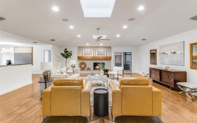 7278 Joyce Way, Dallas, TX 75225 - living area featuring ceiling fan, light wood-type flooring, a fireplace, a skylight, and vaulted ceiling