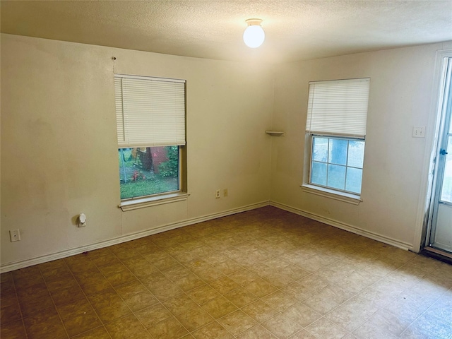 402 N Nash St, Kaufman, TX 75142 - spare room featuring a textured ceiling, baseboards, and tile patterned floors