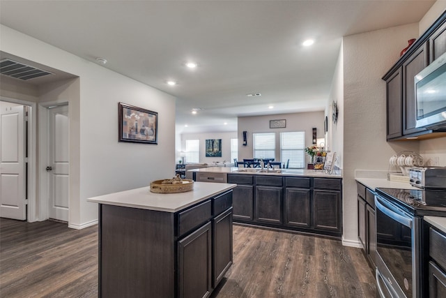 1316 Briar Hill Dr, Denton, TX 76207 - kitchen with stainless steel appliances, dark wood-style floors, light countertops, a center island, and recessed lighting