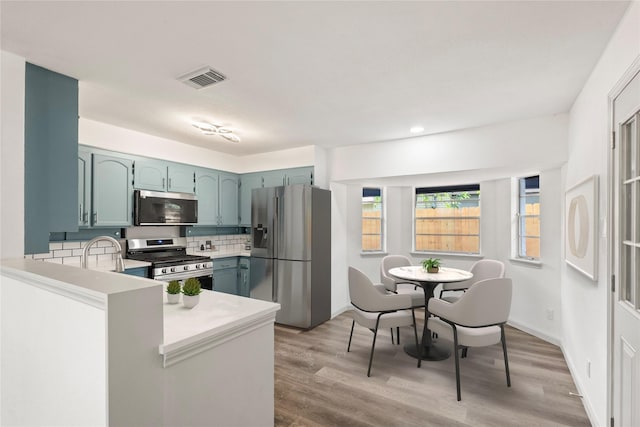 3812 David Ln, Forest Hill, TX 76119 - kitchen featuring appliances with stainless steel finishes, light countertops, light wood-type flooring, recessed lighting, and a peninsula
