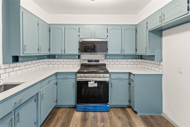 3812 David Ln, Forest Hill, TX 76119 - kitchen with appliances with stainless steel finishes, backsplash, dark wood-type flooring, and light countertops