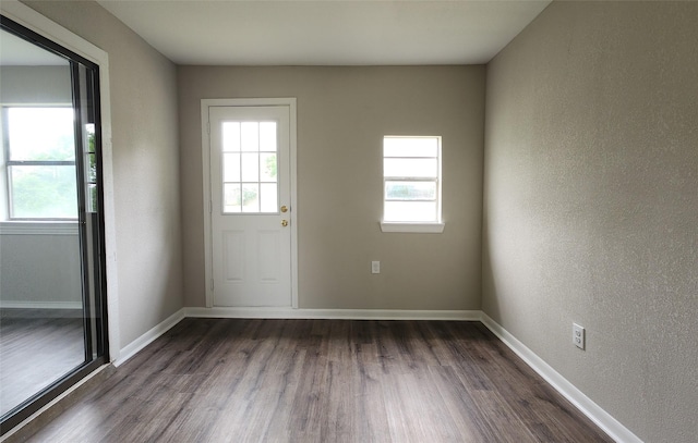 3308 29th St, Fort Worth, TX 76111 - doorway with dark wood-style flooring, healthy amount of natural light, and baseboards