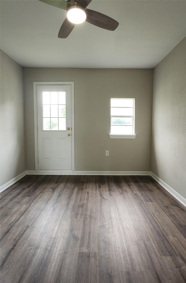 3308 29th St, Fort Worth, TX 76111 - empty room featuring healthy amount of natural light, dark wood-style flooring, ceiling fan, and baseboards