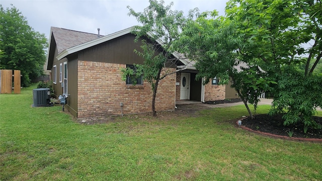 3308 29th St, Fort Worth, TX 76111 - view of front of house with brick siding, a front lawn, cooling unit, and a shingled roof