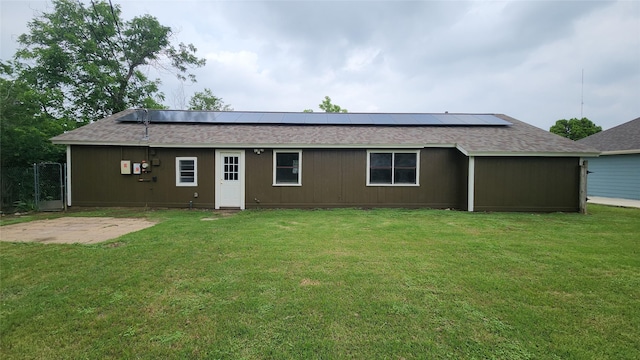 3308 29th St, Fort Worth, TX 76111 - rear view of house featuring a shingled roof, roof mounted solar panels, and a yard