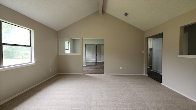 3308 29th St, Fort Worth, TX 76111 - carpeted empty room featuring beam ceiling, baseboards, high vaulted ceiling, and a textured ceiling