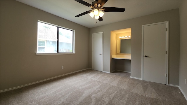 3308 29th St, Fort Worth, TX 76111 - unfurnished bedroom with light colored carpet, baseboards, ensuite bathroom, and ceiling fan