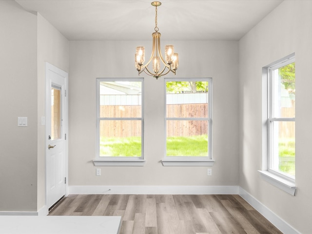 4416 Green Acres Ct, Arlington, TX 76017 - unfurnished dining area featuring a chandelier, wood finished floors, and baseboards