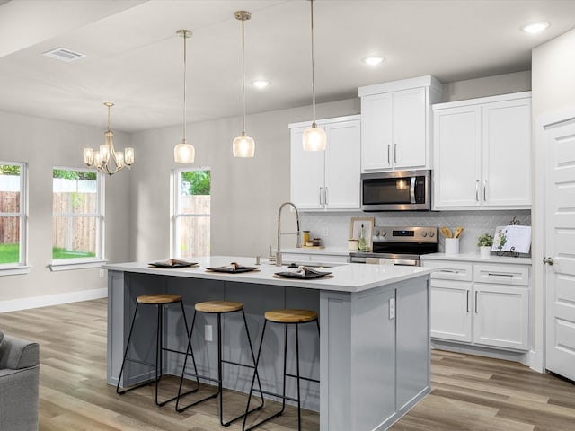 4416 Green Acres Ct, Arlington, TX 76017 - kitchen featuring stainless steel appliances, light wood-style floors, backsplash, a kitchen breakfast bar, and recessed lighting