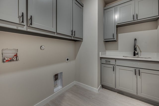 530 E Lamar St, Palmer, TX 75152 - washroom with electric dryer hookup, light wood-style flooring, cabinet space, and baseboards