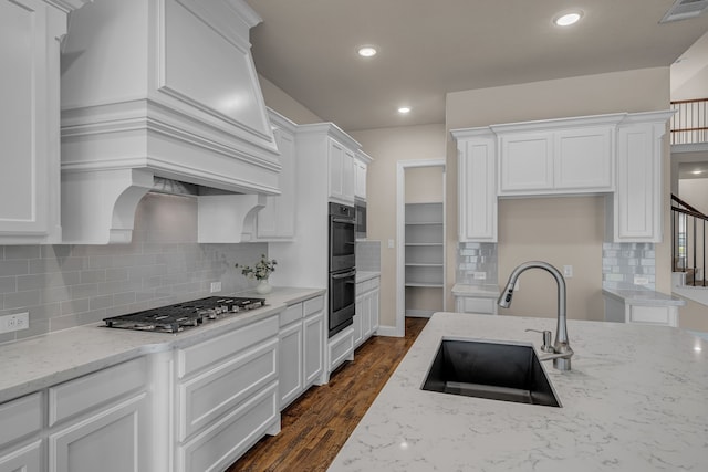 7819 Uxbridge Dr, Irving, TX 75063 - kitchen with a sink, stainless steel gas stovetop, double oven, white cabinetry, and recessed lighting