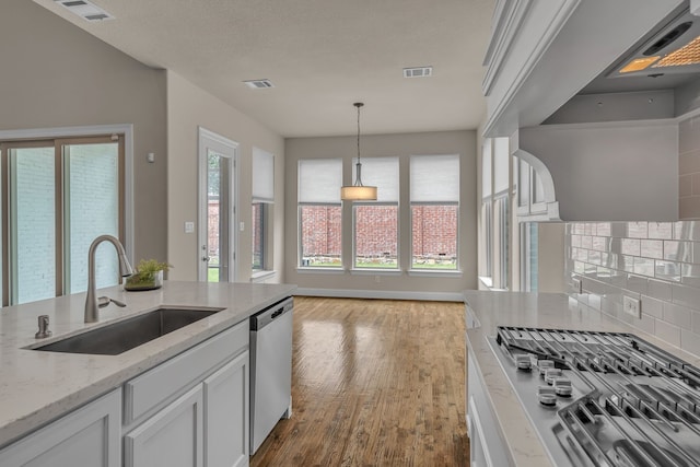 7819 Uxbridge Dr, Irving, TX 75063 - kitchen featuring stainless steel appliances, a sink, wood finished floors, and backsplash