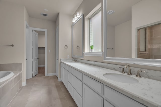 7819 Uxbridge Dr, Irving, TX 75063 - bathroom with double vanity, a bath, tile patterned flooring, and a spacious closet