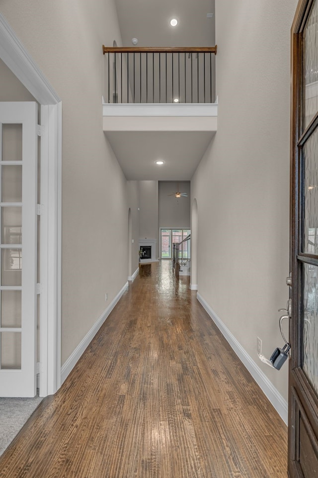 7819 Uxbridge Dr, Irving, TX 75063 - entryway with ceiling fan, a high ceiling, wood finished floors, baseboards, and a fireplace