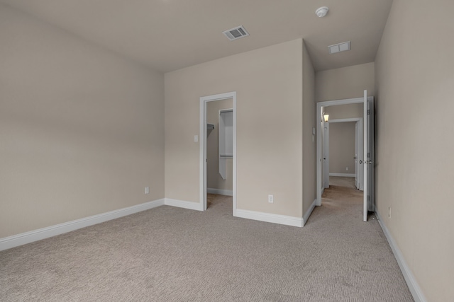 7819 Uxbridge Dr, Irving, TX 75063 - unfurnished bedroom featuring light carpet, baseboards, and a walk in closet