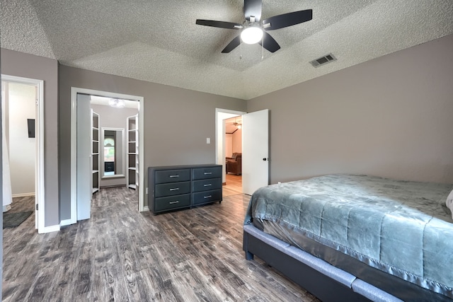 250 E Bancroft Dr, Garland, TX 75040 - bedroom with dark wood finished floors, a textured ceiling, baseboards, a walk in closet, and ceiling fan