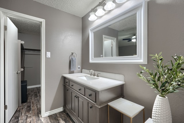 250 E Bancroft Dr, Garland, TX 75040 - bathroom featuring a textured ceiling, wood finished floors, vanity, ceiling fan, and baseboards
