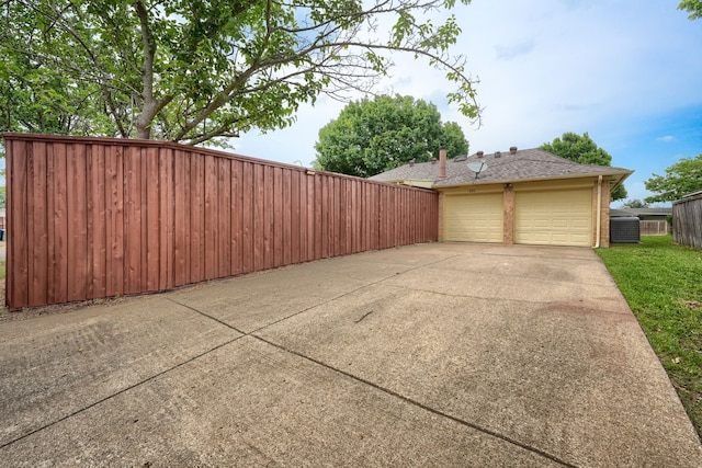 250 E Bancroft Dr, Garland, TX 75040 - view of home's exterior featuring central air condition unit, a garage, brick siding, and concrete driveway