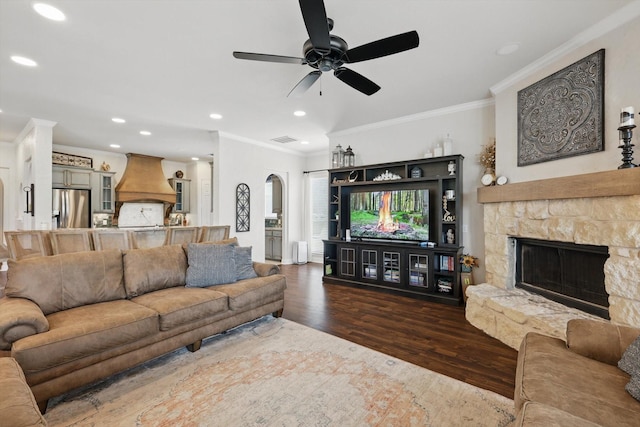 1000 Van Zandt Ct, Haslet, TX 76052 - living area with dark wood finished floors, crown molding, a stone fireplace, a ceiling fan, and arched walkways