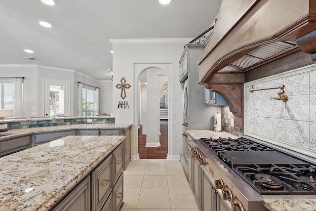 1000 Van Zandt Ct, Haslet, TX 76052 - kitchen featuring stovetop with downdraft, arched walkways, ornamental molding, light stone countertops, and recessed lighting