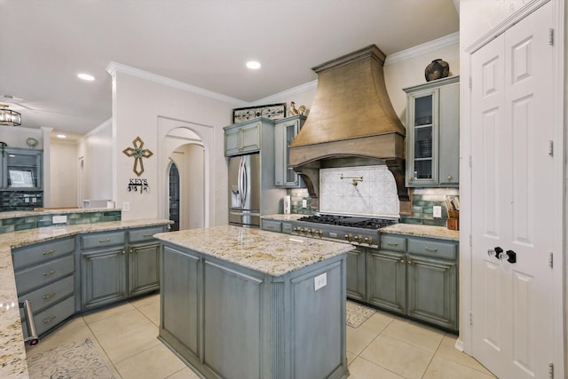1000 Van Zandt Ct, Haslet, TX 76052 - kitchen with premium range hood, appliances with stainless steel finishes, light tile patterned floors, decorative backsplash, and ornamental molding