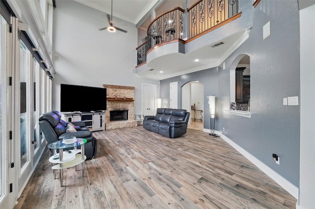 2056 Willow Bend Dr, Oak Leaf, TX 75154 - living room featuring crown molding, a towering ceiling, baseboards, wood finished floors, and a stone fireplace