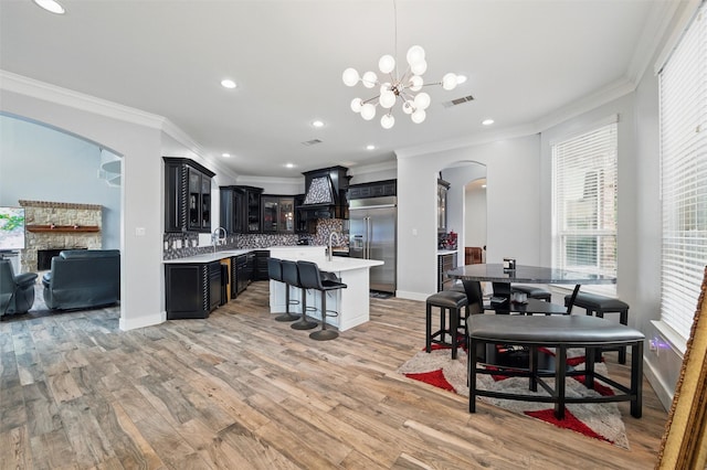 2056 Willow Bend Dr, Oak Leaf, TX 75154 - kitchen with arched walkways, stainless steel built in fridge, light countertops, ornamental molding, and a chandelier
