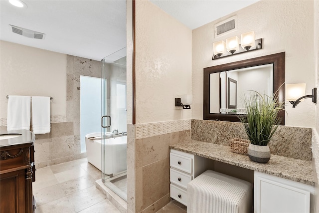 3309 Citation Dr, Dallas, TX 75229 - full bathroom featuring tile walls, vanity, a stall shower, a bathtub, and a wainscoted wall