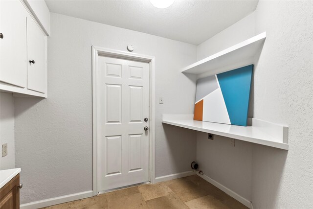 3309 Citation Dr, Dallas, TX 75229 - laundry area with hookup for an electric dryer, light stone finish floors, an office area, cabinet space, and baseboards