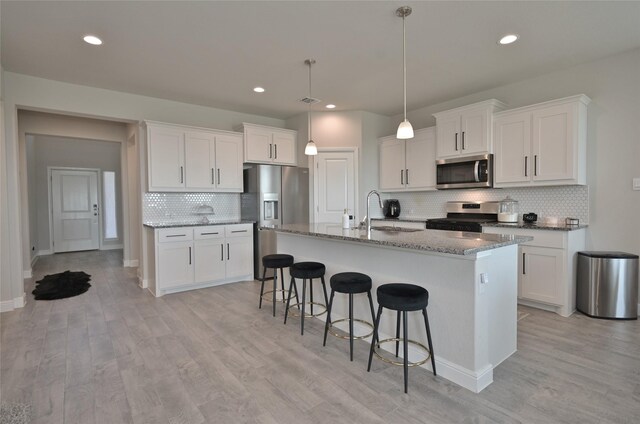 186 Dogwood Ave, Rhome, TX 76078 - kitchen with stainless steel appliances, a sink, backsplash, a kitchen bar, and white cabinetry
