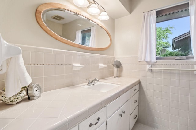 1113 Stanley St, Denton, TX 76201 - bathroom featuring vanity, wainscoting, and tile walls