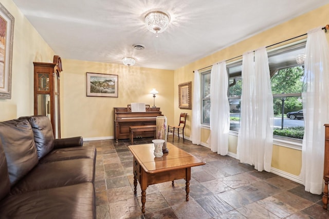 1113 Stanley St, Denton, TX 76201 - living area with stone tile flooring, baseboards, and a chandelier