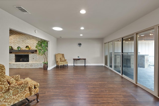 2612 Windsor Pl, Plano, TX 75075 - living area with wood finished floors, a brick fireplace, recessed lighting, brick wall, and baseboards