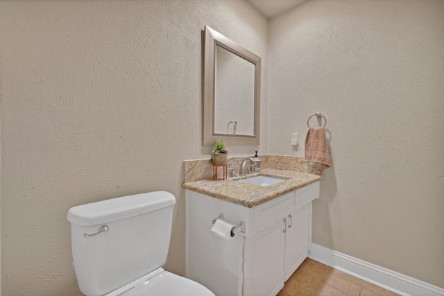 2612 Windsor Pl, Plano, TX 75075 - half bathroom featuring toilet, vanity, tile patterned floors, and baseboards