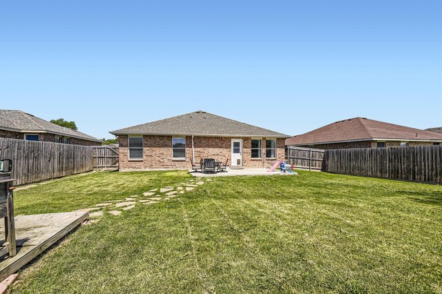 1806 Willowbrook Dr, Terrell, TX 75160 - back of property featuring a patio, brick siding, and a shingled roof