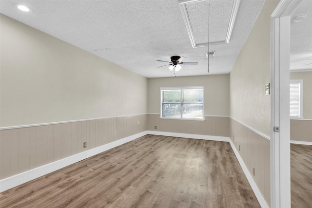 106 King Ave, Howe, TX 75459 - spare room with attic access, wood finished floors, a textured ceiling, ceiling fan, and a wainscoted wall